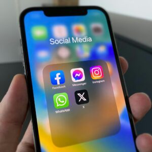 a person holding a cell phone with social media on the screen